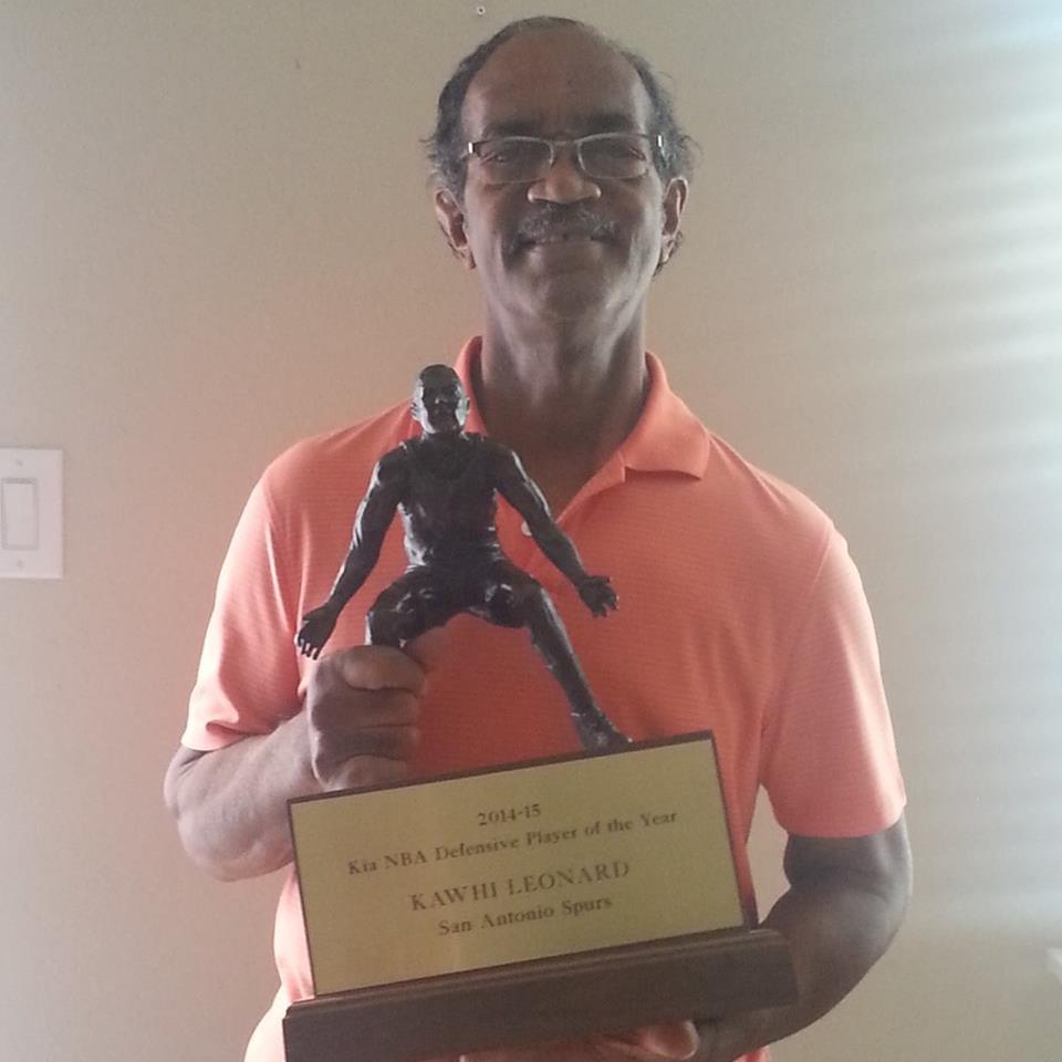 Kawhi Leonard's girlfriend Kishele Shipley's father posing with Leonard's MVP award.